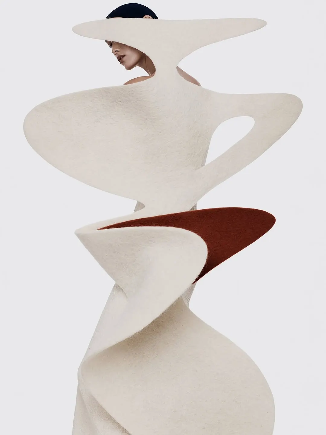 Abstract white sculptural form against a cream wall